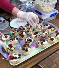 A hand in gloves holding a tray of food

AI-generated content may be incorrect.