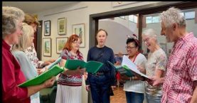 A group of people holding green folders

Description automatically generated