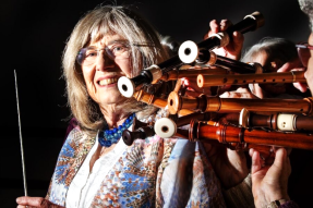 A person is holding a beautifully decorated traditional wooden instrument, possibly a violin or a similar stringed instrument.

AI-generated content may be incorrect.